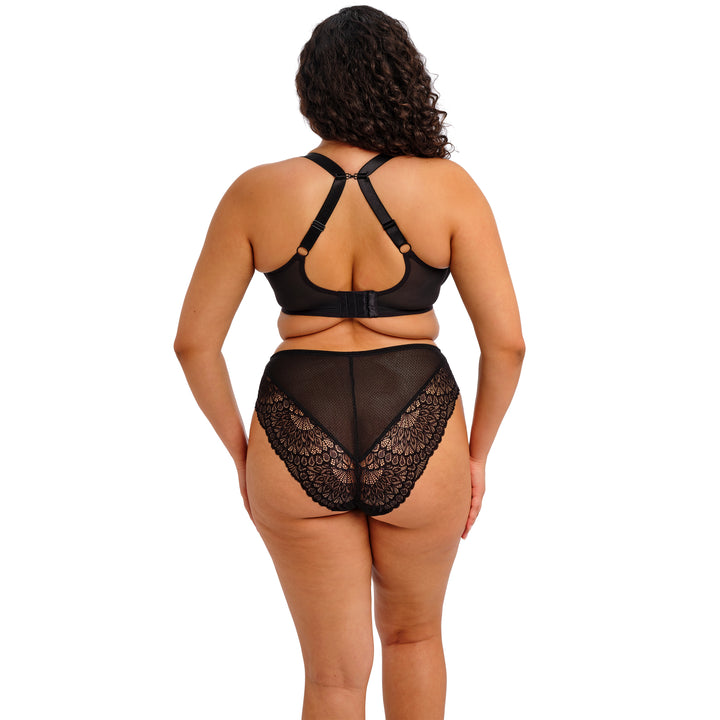 Woman wearing a black lace lingerie set on a white background