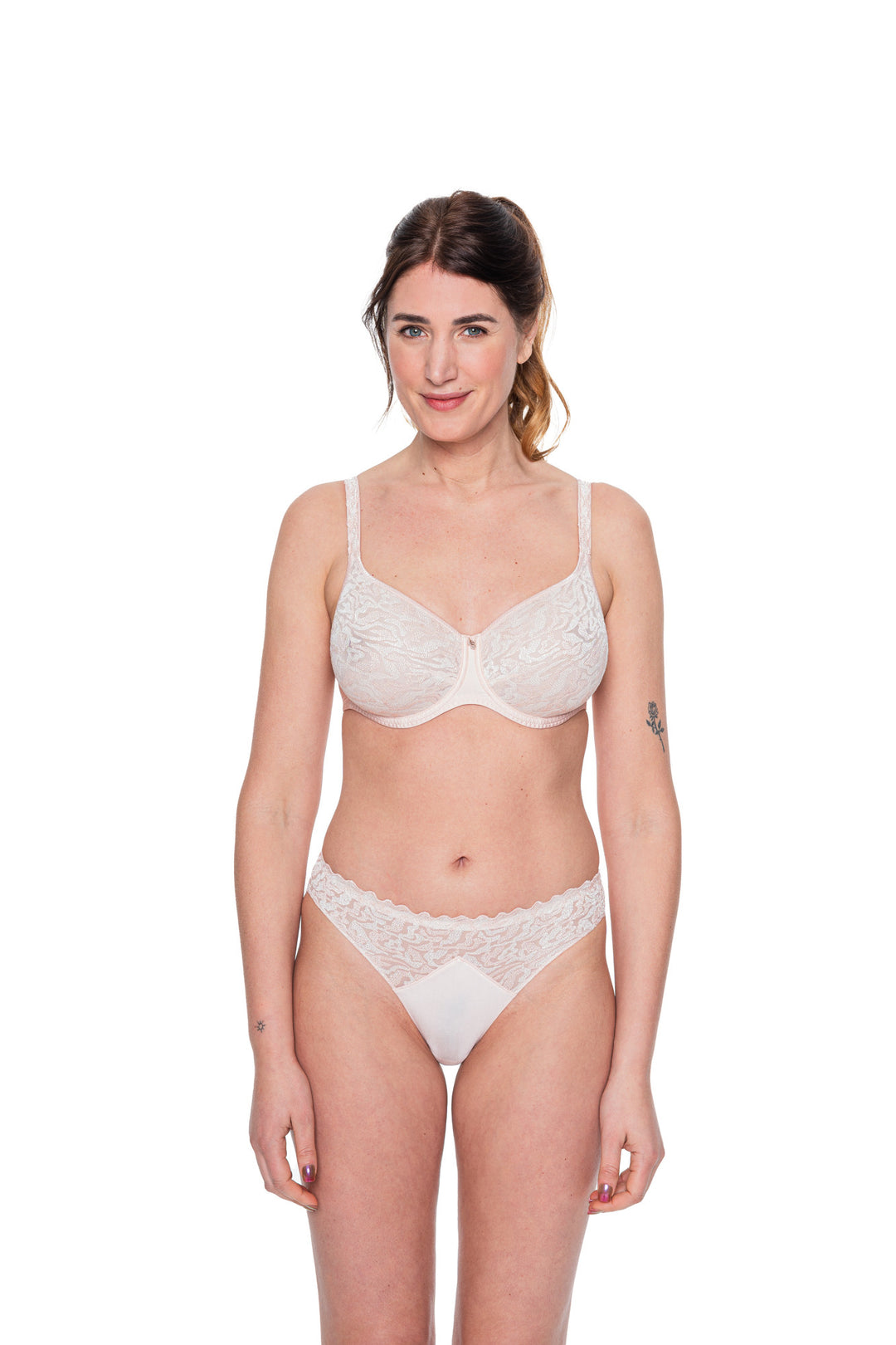 Woman wearing a white lace bra and panties set on a white background
