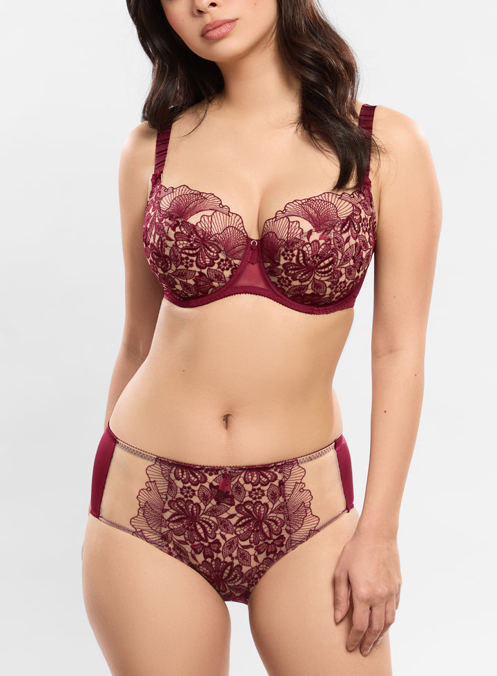 Woman wearing a maroon lace lingerie set on a white background
