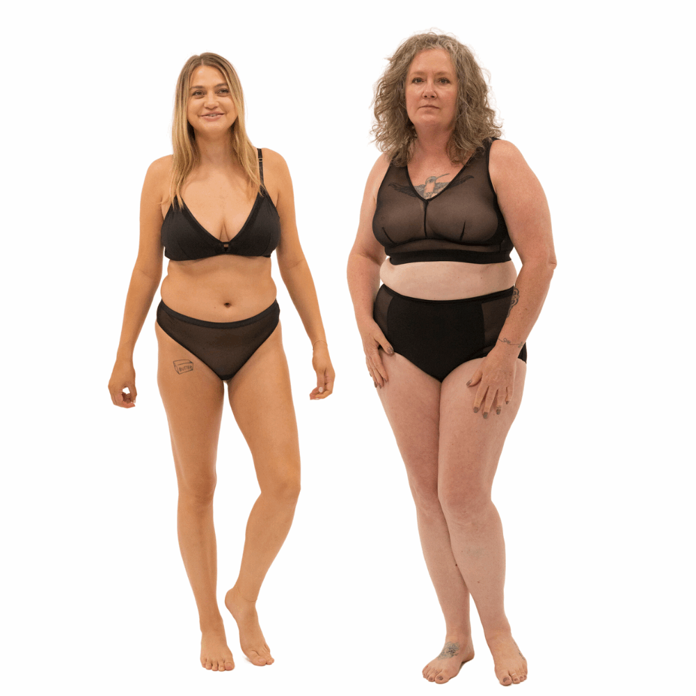 Two women wearing black lingerie on a white background