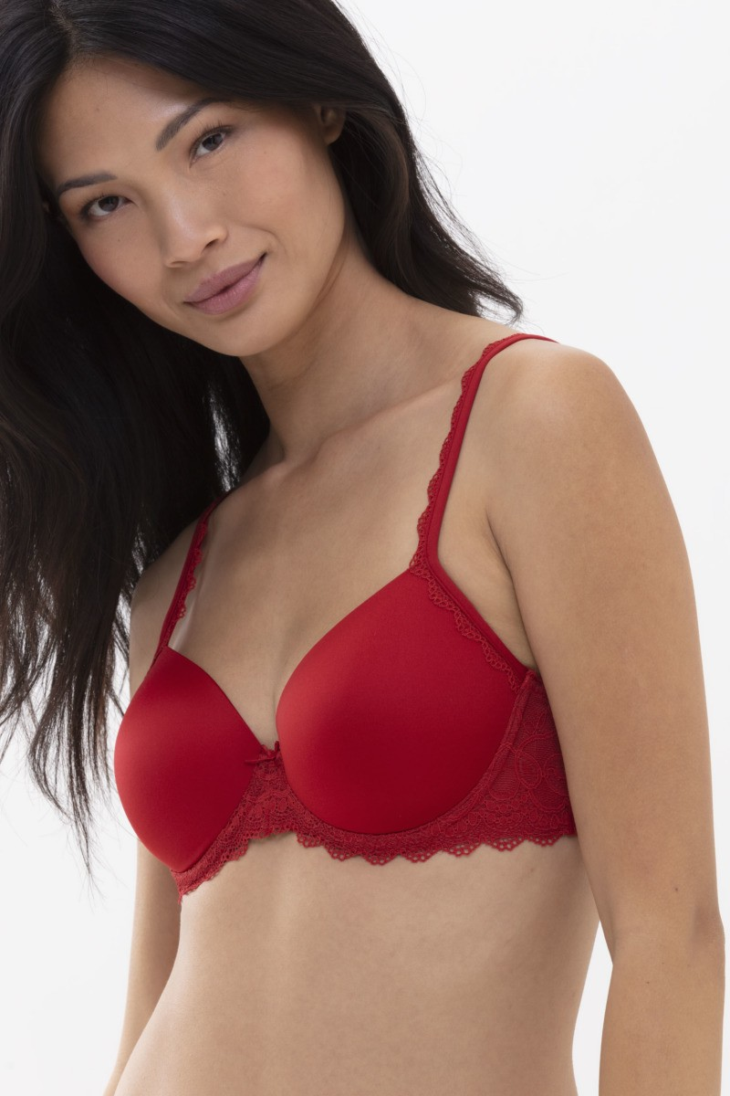 Woman wearing a red bra against a white background