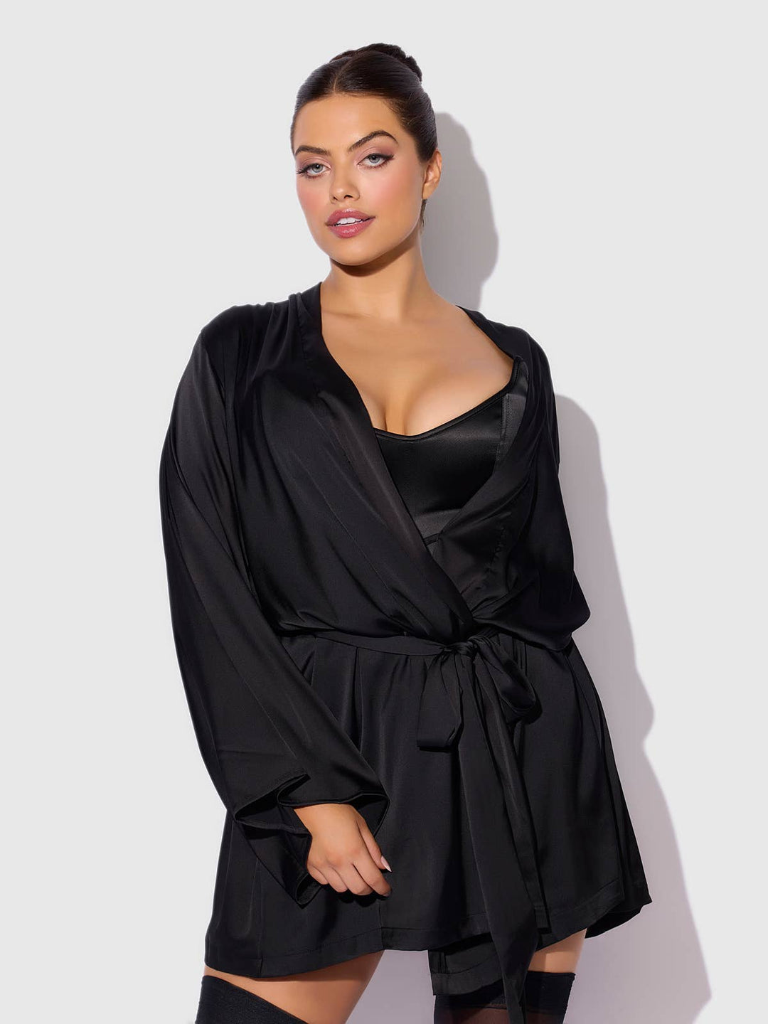 Woman wearing a black satin robe against a white background