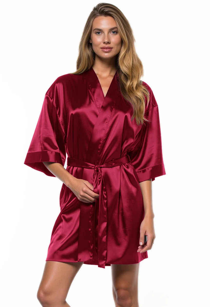 Woman wearing a burgundy satin robe on a white background