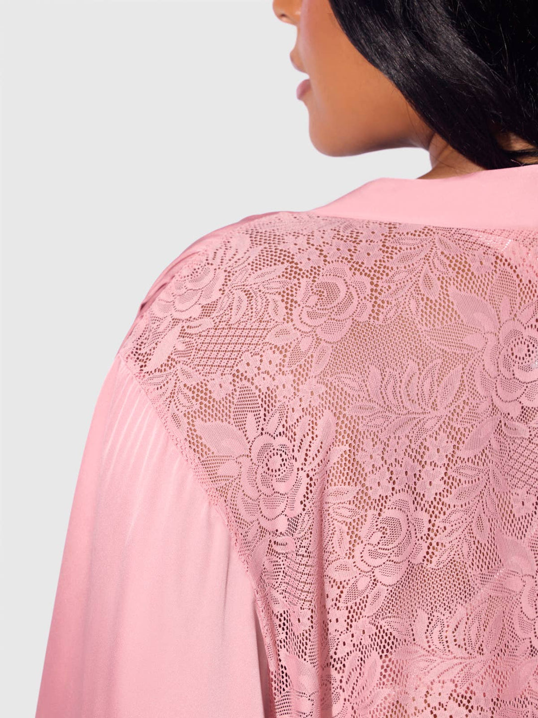 Close-up of a pink lace garment with a plain background