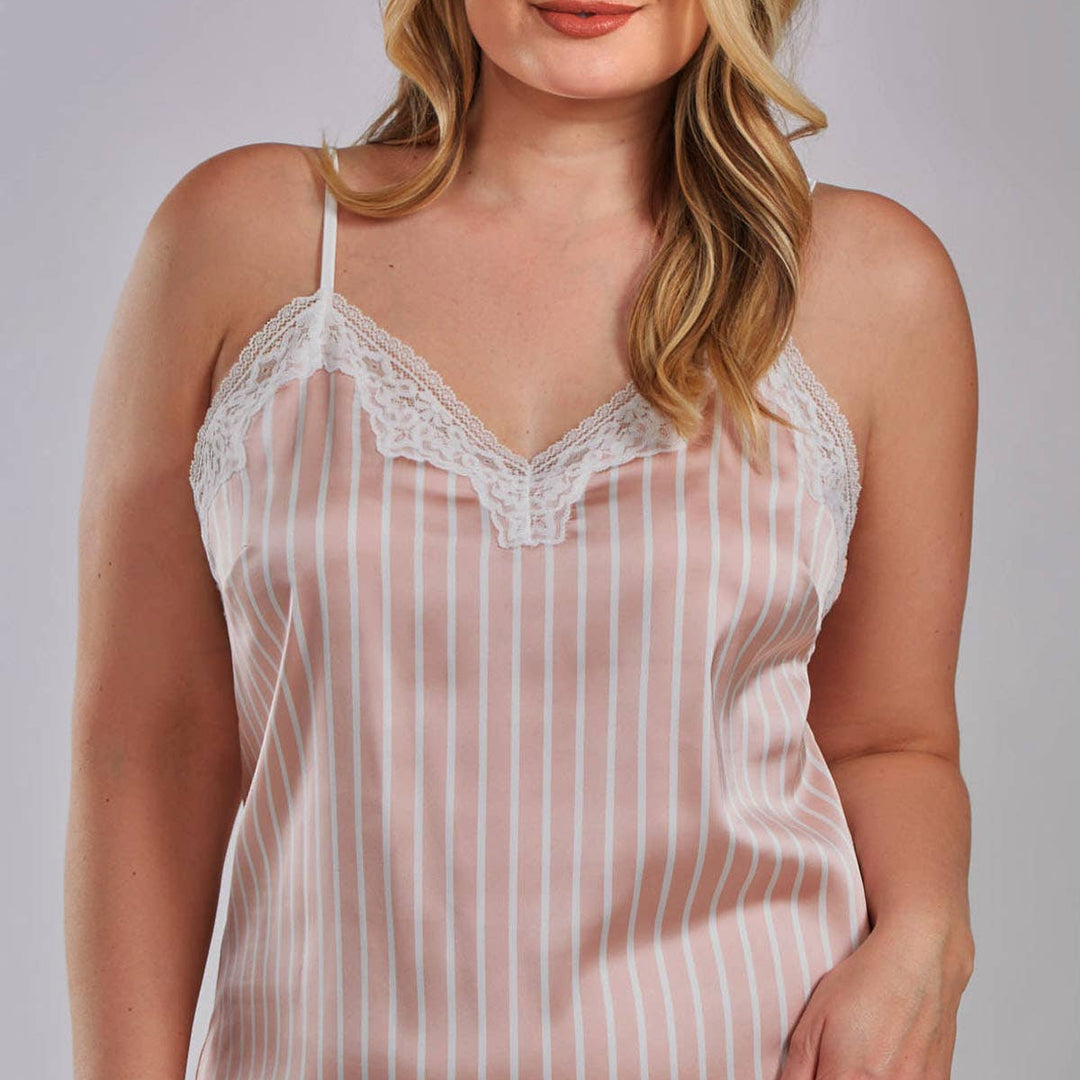 Woman wearing a sheer striped nightgown with lace trim on a plain background
