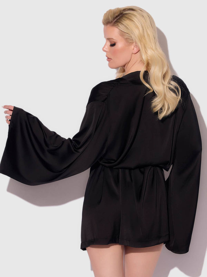 Woman wearing a black satin robe against a white background