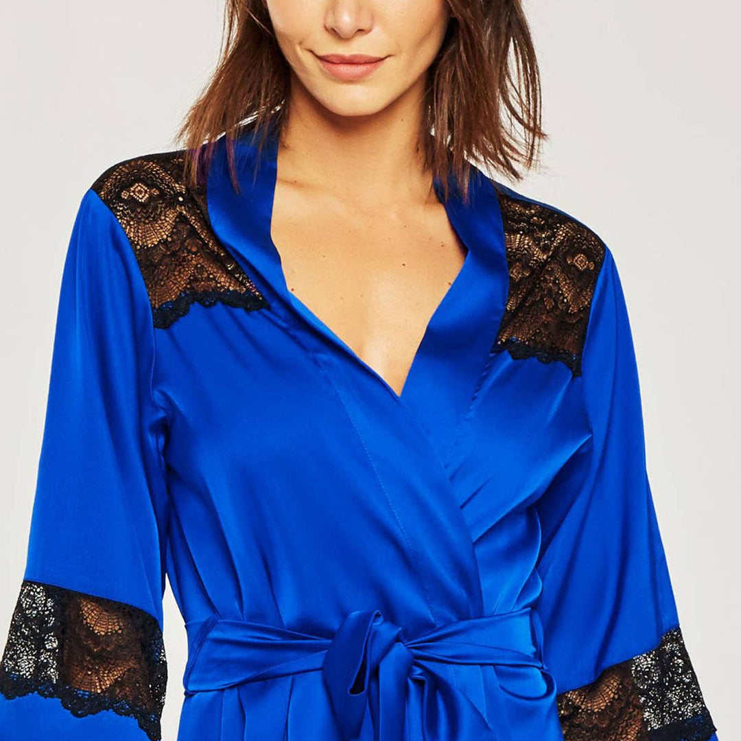 Woman wearing a blue robe with black lace details on a white background
