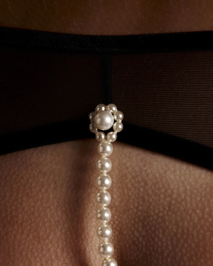 Pearl g-string spanish lingerie against a brown background
