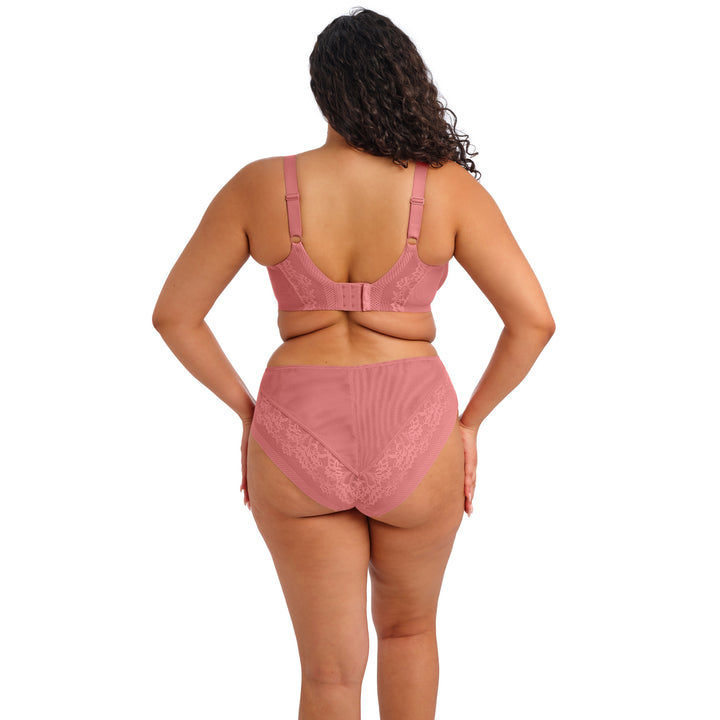 Woman wearing a pink lingerie set on a white background