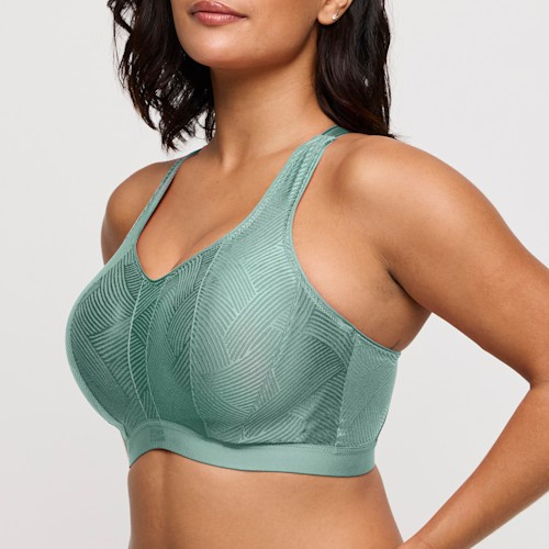 Woman wearing a green sports bra against a plain background