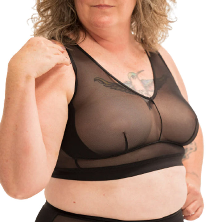 Person wearing a black sheer top and shorts set on a white background