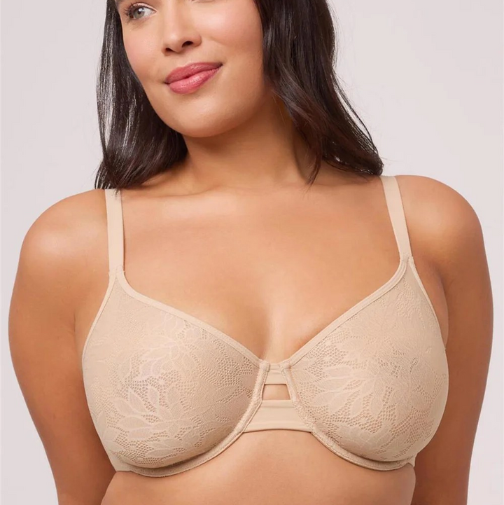 Woman wearing a beige bra against a plain background