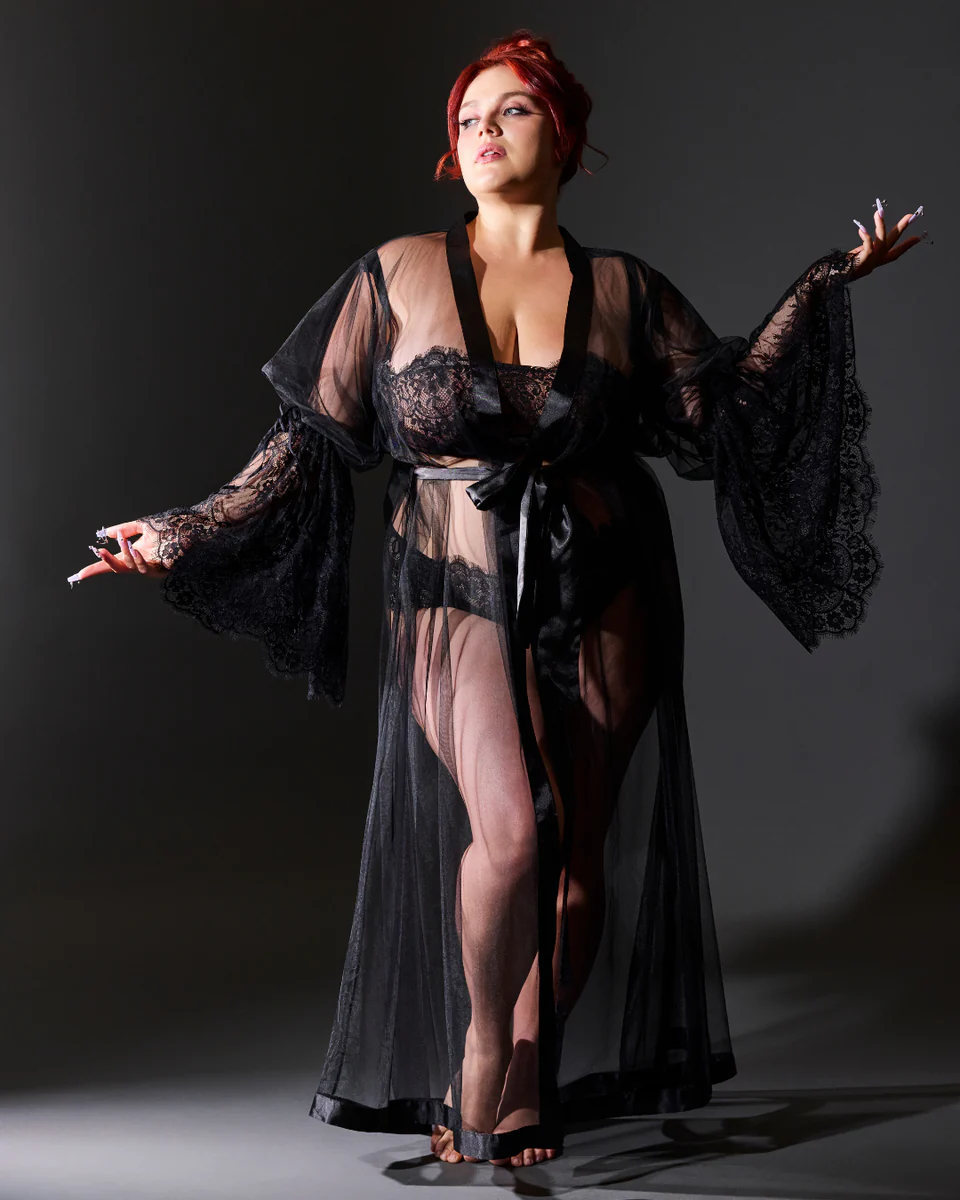 Woman wearing a black lace robe against a dark background
