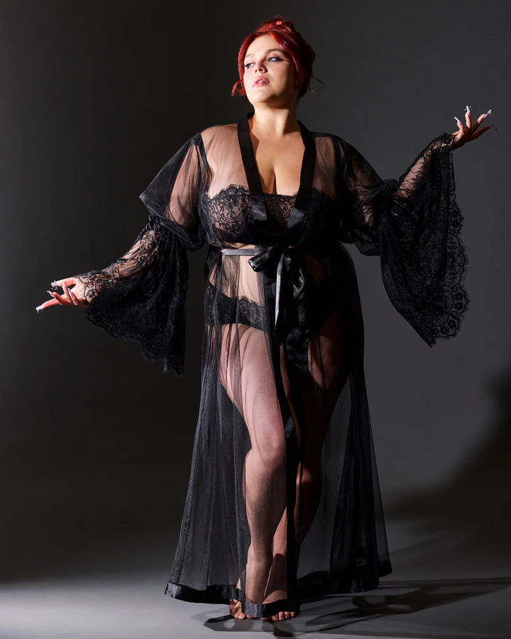 Woman wearing a black lace robe against a dark background