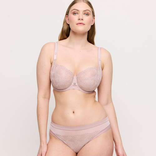 Woman wearing a matching bra and underwear set on a plain background